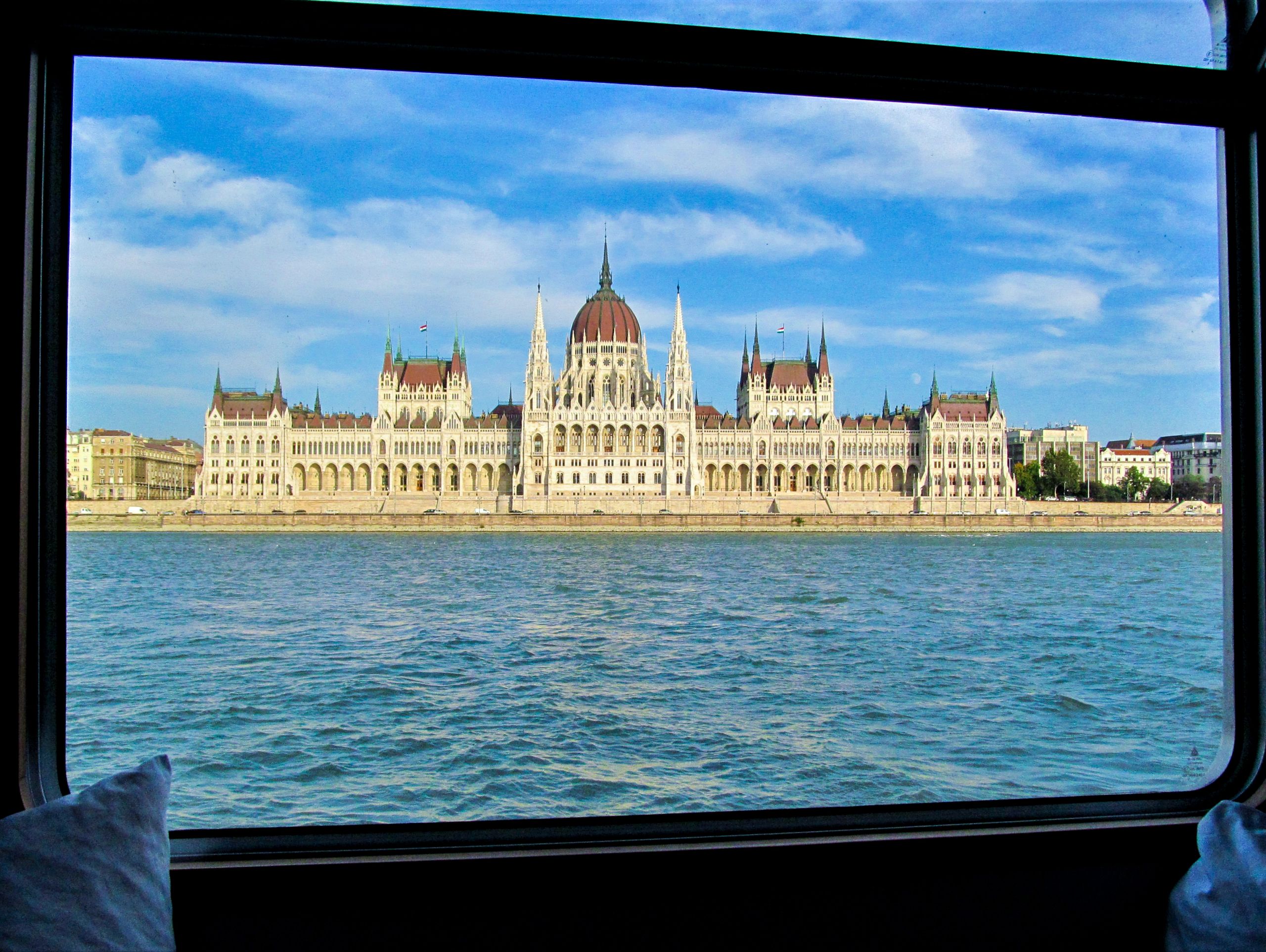Blick auf das ungarische Parlament von einem Fenster mit Blick auf die Donau.